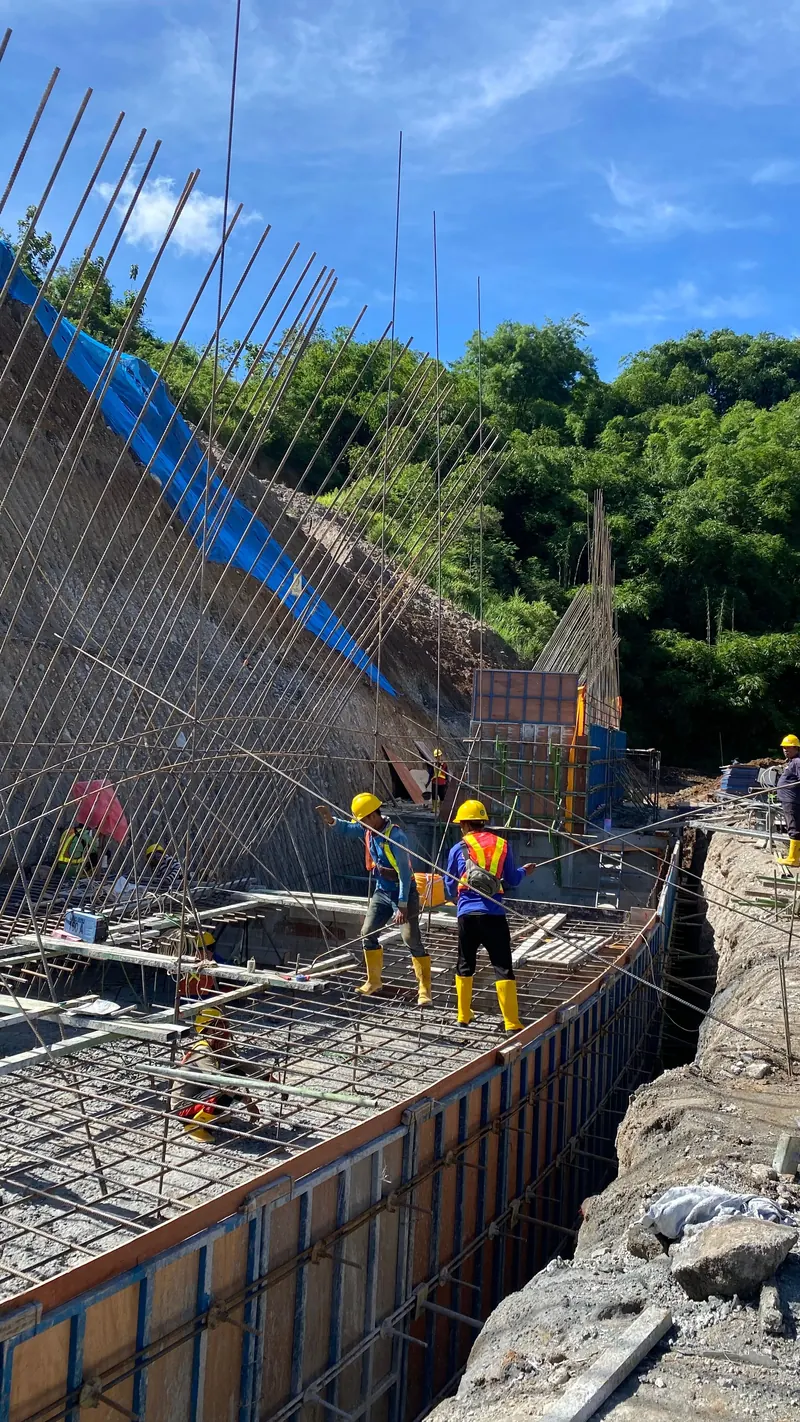 Cuadrilla de obra con casco y chaleco trabajando en Bogotá